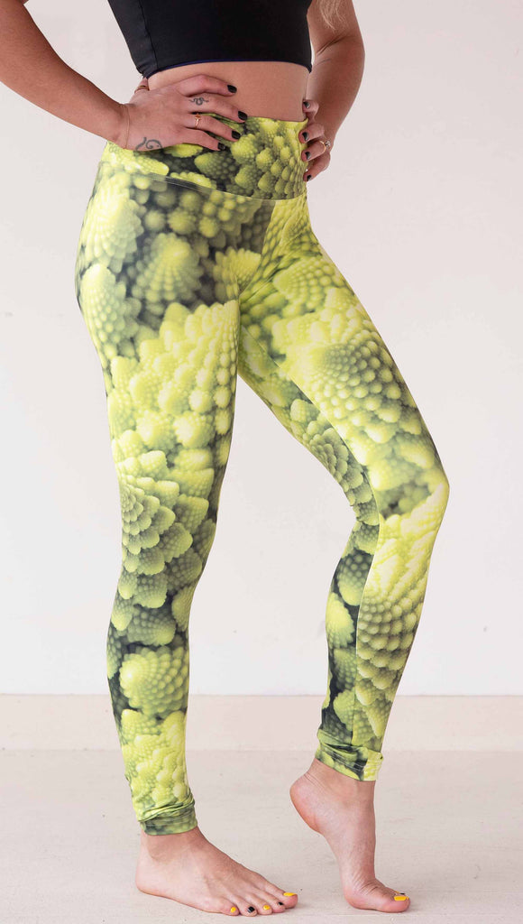 Model wearing WERKSHOP Romanesco Cauliflower Leggings. The fabric is printed with macro fractal details with bright green/yellow tones.