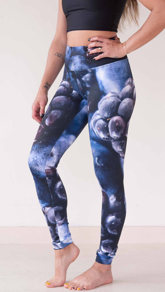 Model wearing WERKSHOP leggings printed with a macro images of blueberries and blackberries. The leggings are vibrant rich blues and deep dark purples.