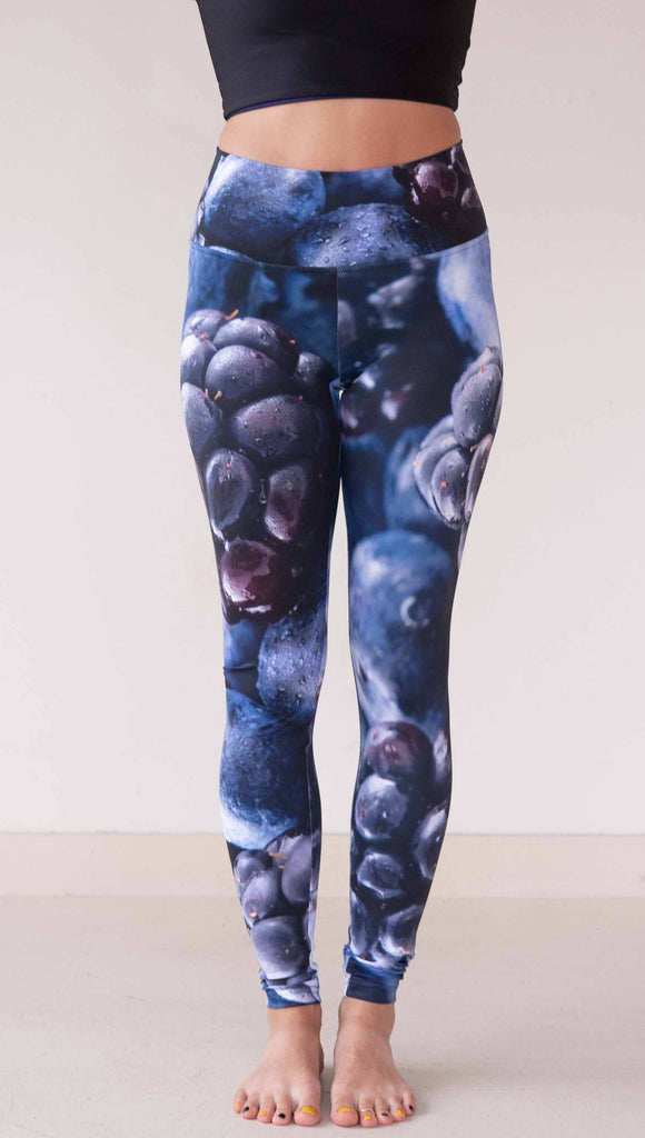 Model wearing WERKSHOP leggings printed with a macro images of blueberries and blackberries. The leggings are vibrant rich blues and deep dark purples.