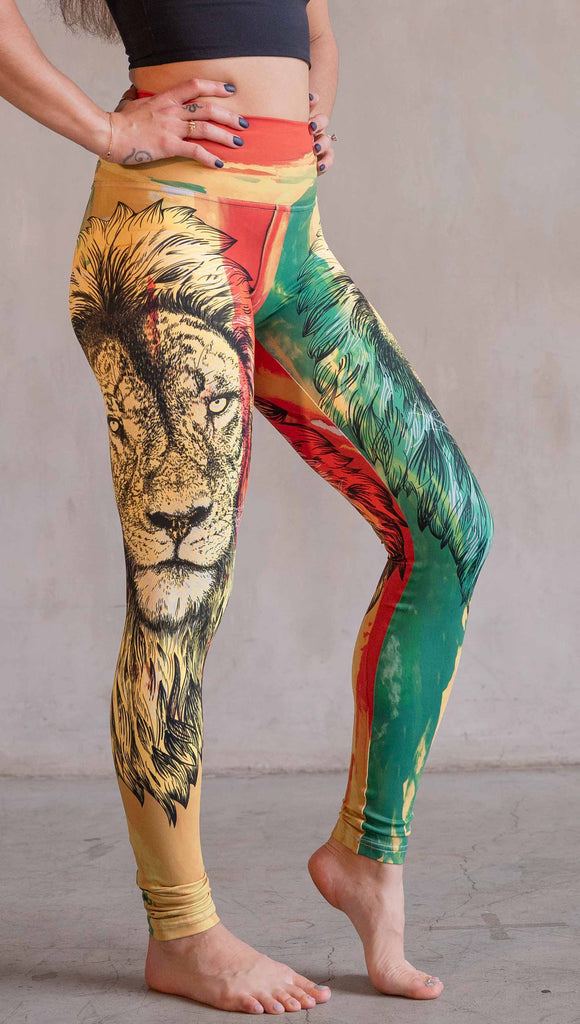 Model wearing WERKSHOP Lion of Zion Athleisure Leggings. The leggings feature a hand illustration of a lion over organic brustrokes in Rastafarian colors.