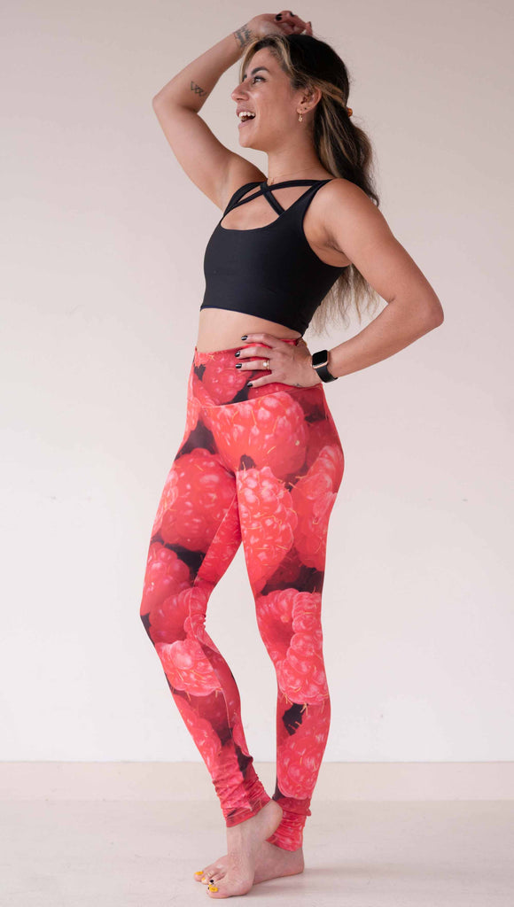 Model wearing WERKSHOP leggings printed with a macro image of bright bold red raspberries.