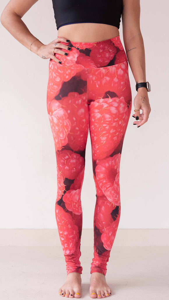 Model wearing WERKSHOP leggings printed with a macro image of bright bold red raspberries.