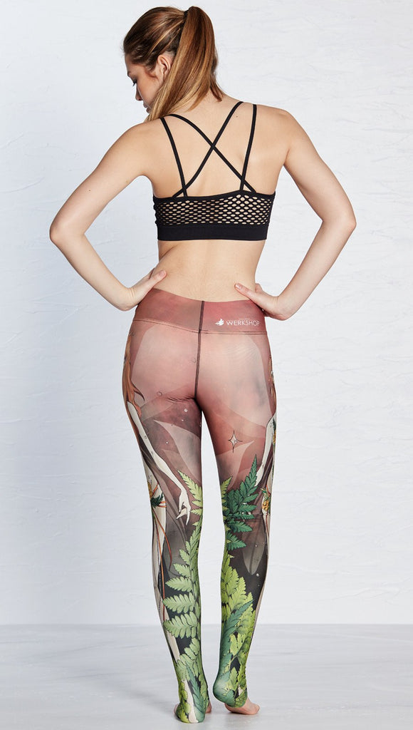 back view of model wearing pixie themed printed full length leggings