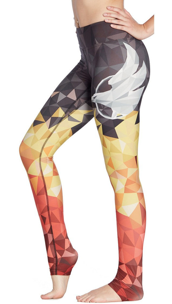 close up left side view of model wearing ombre flame polygon themed printed full length leggings with large eagle on the side