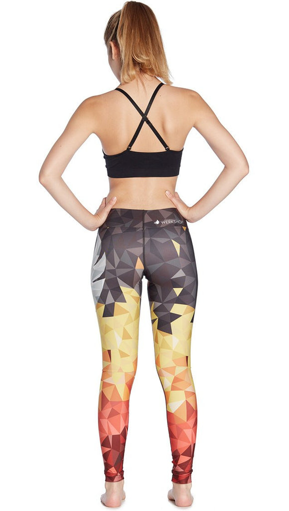 back view of model wearing ombre flame polygon themed printed full length leggings with large eagle on the side