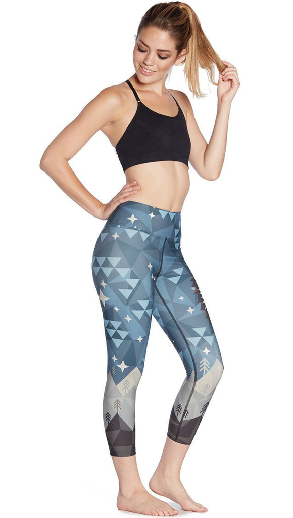 right side view of model wearing geometric wolf / dog face printed capri leggings