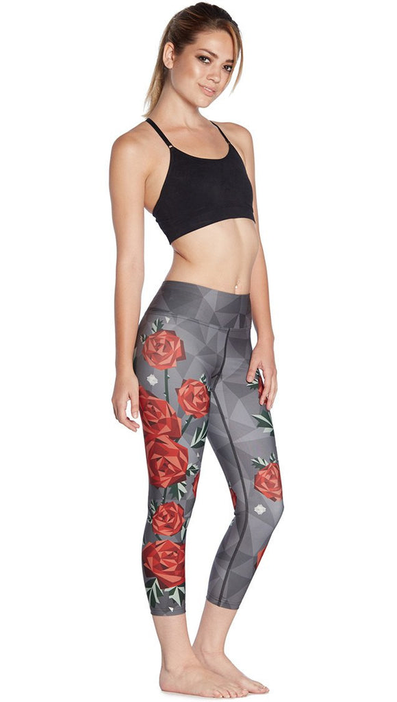 right side view of model wearing geometric roses themed printed capri leggings